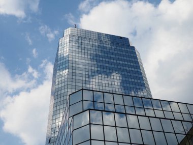 Mavi Gök ve Beyaz Bulutları Yansıtan Köşeli Modern Cam Ofis Kulesi