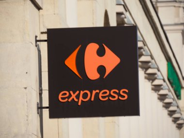 Carrefour Ekspres Tabelasında Kara Arkaplan Logosu ve Duvara monte edilmiş Orange Logosu