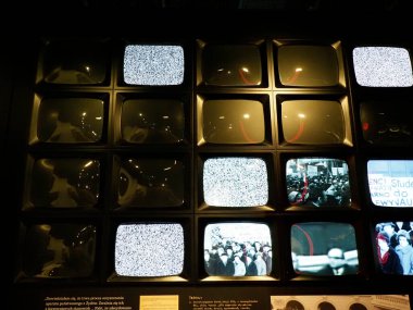 Karanlık Sergi Salonunda Tarihsel Görüntüleri Gösteren Çoklu Eski Televizyon Ekranlı Müze Kurulumu