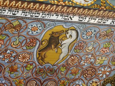 Gösterişli çiçek desenleri ve İbranice Metin Dekorasyonlarıyla Geleneksel Yahudi Sinagogu Tavanı Üzerine Canlı Aslan Sembolü