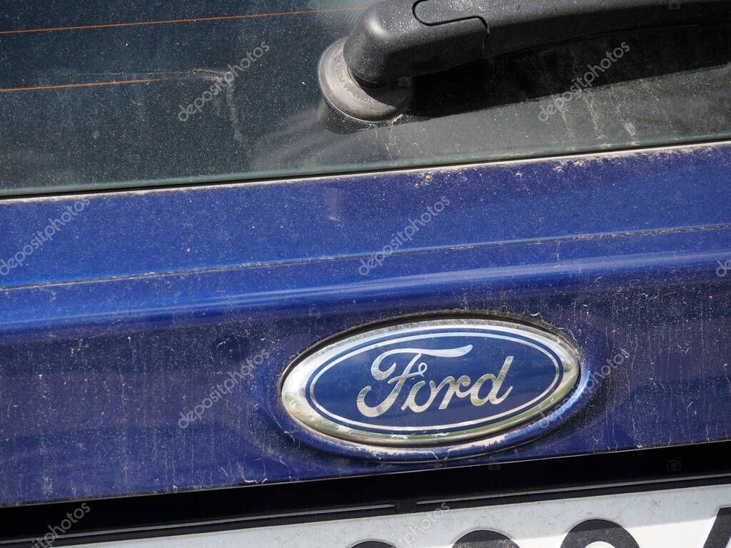 Close-Up Detail of Blue Ford Car with Iconic Oval Logo Badge on Vehicle Front
