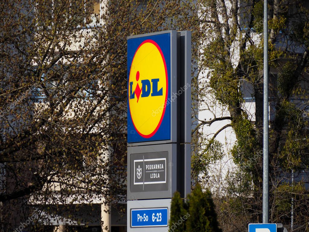 Lidl Supermarket Sign Among Spring Trees Showcasing Recognizable Yellow and Blue Brand Identity