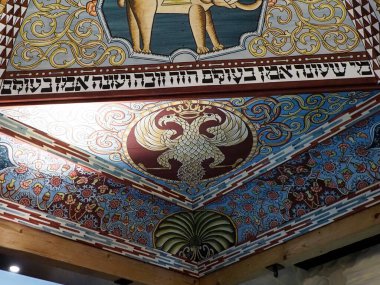 Sinagog Tavanı 'nın Karmaşık Köşe Detayları Hayvan Motifleri ve Süslü Altın Sınırlar ile Mavi Arkaplan Karşısında İbranice Metin Gösteriliyor