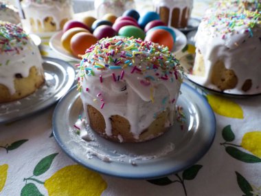 Beyaz buzlu Paskalya Kulich Pastası ve Renkli Yumurta Tabağı Üzerine Renkli Şekerlemeler