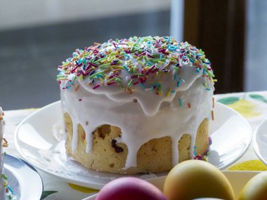 Beyaz Parlak Ev Yapımı Paskalya Pastası ve Beyaz Tabakta Renkli Şekerler Yumuşak Bahar Arkaplanına Karşı