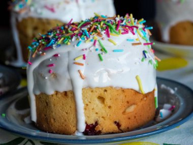 Taze pişmiş geleneksel Kulich Paskalya Ekmeği. Beyaz jöleli ve Metal Servis Tabağı üzerine renkli serpiştirilmiş.