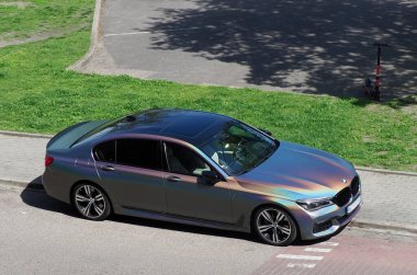 Spor Tasarımlı Lüks Sedan Sunny Day 'de Green Lawn ile birlikte Residential Street' e park etmiş.