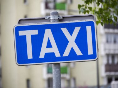 Avrupa 'da Bulanık Şehir Arkaplanına Karşı Metal Kutbuna Mavi Taksi Tabelası