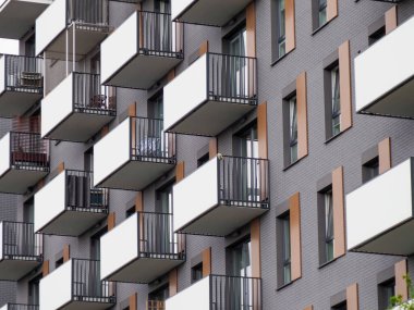 Kentsel Ayarlarda Portakal ve Gri Cephe ve Beyaz Balkonlu Modern Konut Binası