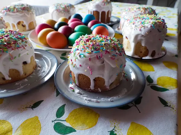 Limon desenli masa örtüsü üzerine boyanmış yumurtalarla birlikte geleneksel Paskalya Kulich Pastaları