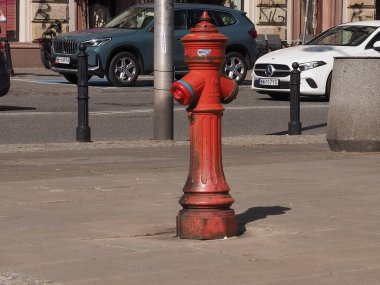 Güneşli bir günde Şehir merkezinde Şehir Kaldırımında Tek Başına Duran Parlak Kırmızı Yangın Yangın Musluğu