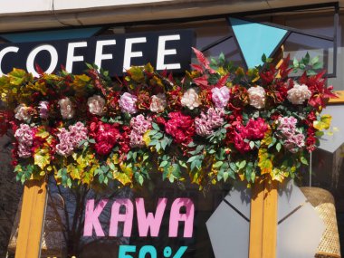 Çiçek Dekorasyonu ve Pembe KAWA Tabelasıyla Canlı Kahve Dükkanı Penceresi% 50 indirimli