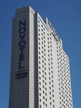 Açık Mavi Gökyüzü Şehir Konukseverliğine Karşı Dikey İşaretli Uzun Novotel Oteli Gökdeleni