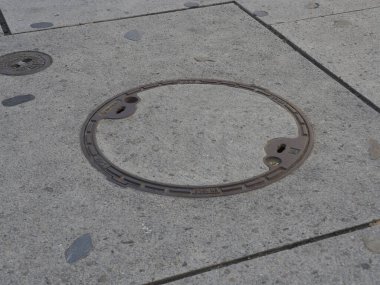 Şehir Kaldırımına Gömülü Boş Metal Halka Dairesel Altyapı Elementi Gösteriyor
