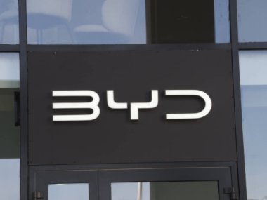 Beyaz BYD Elektrikli Taşıt Şirketi Logosu Kentsel İş Bölgesindeki Modern Siyah İnşaat Cephesi