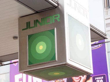 Kentsel Alışveriş Caddesinde Yeşil Çember Logosu olan Modern JUNIOR Marka İşareti