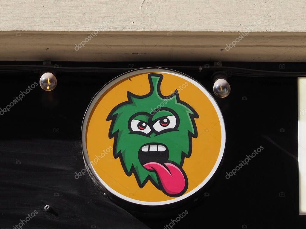 Angry Green Monster Logo with Yellow Background Mounted on Business Entrance Wall