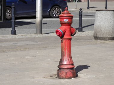 Parlak Kırmızı Yangın Yangın Musluğu Şehir Kaldırımında Taş Kaldırım ve Trafik Postasının yanında duruyor