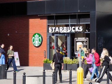 Starbucks Kahve Dükkanı Müşterilerin Şehir Alışveriş Sokağı Çevresinin keyfini çıkardığı bir dükkan.