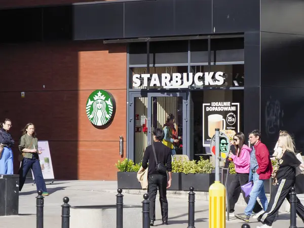 Starbucks Kahve Dükkanı Müşterilerin Şehir Alışveriş Sokağı Çevresinin keyfini çıkardığı bir dükkan.