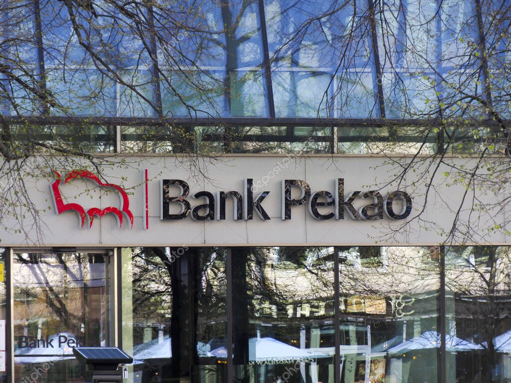 Modern Bank Pekao Facade with Red Logo Against Blue Sky and Winter Trees