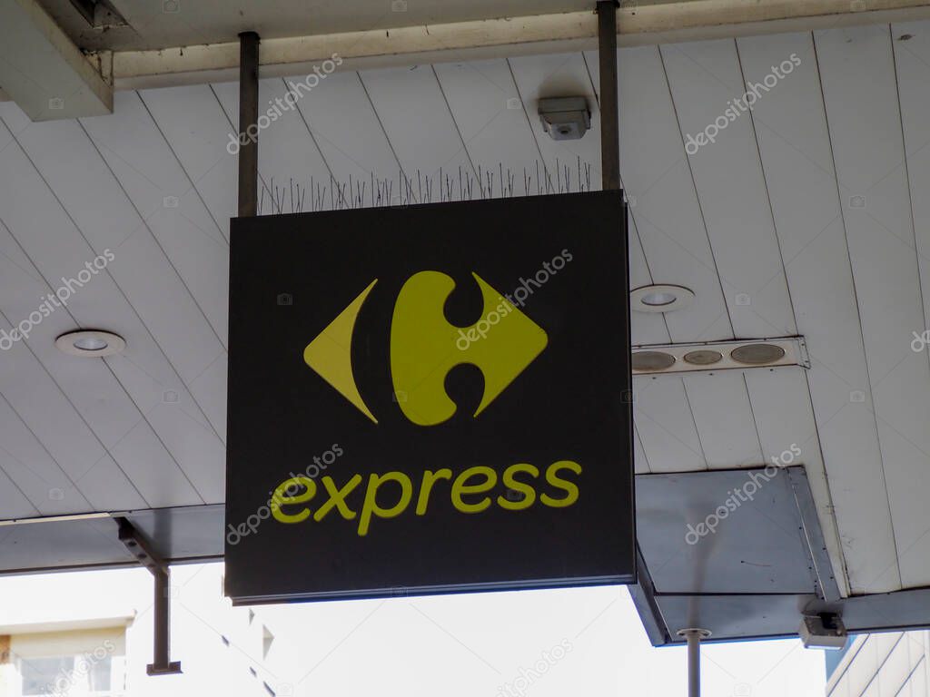 Carrefour Express Black and Yellow Logo Store Sign on Modern Urban Building Exterior