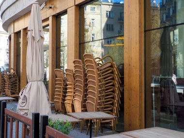 Avrupa Sokak Köşesinde Yığılmış Sandalyeler ve Şemsiyeli Açık Cafe Terası