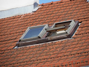 Geleneksel Kırmızı Döşeme Çatısında Modern Skylight Pencereleri Konut Binasında Mimari Karşıtlık Oluşturuyor