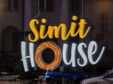 Şehir merkezinde Parlak Sarı ve Turuncu Harflerle Aydınlatılmış Simit Evi Pastanesi Tabelası