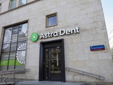 Astra Dent Diş Kliniği Girişi, Şehir Ticari Alanındaki Modern Taş İnşaat Cephesi Yeşil Logosu