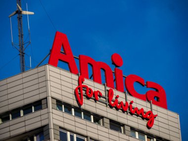 Canlı Kırmızı Amica Elektronik Marka Logosu Modern Bina Çatısı Üzerinde Rüzgar Türbini Mavi Gökyüzüne Karşı