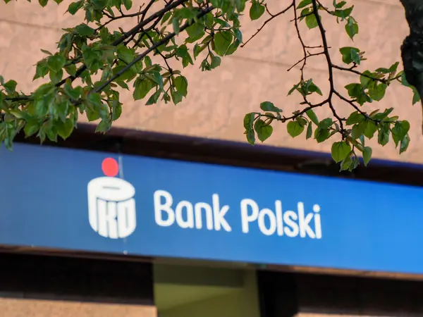 Polski Blue Bankası 'nın Taş Duvara ve Yeşil Yapraklara Karşı Logosuyla Işıklandırılmış İmzası