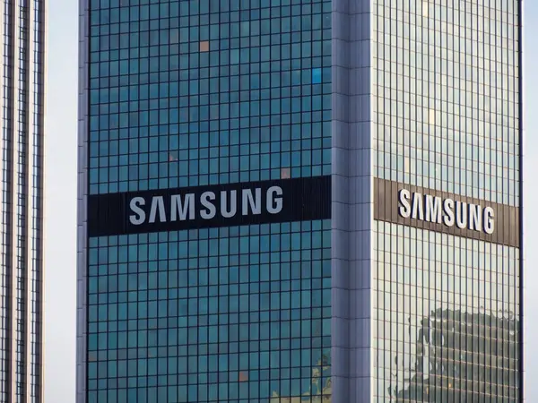 Birçok Samsung Logosu, İş Bölgesi 'nde Çarpıcı Mavi Gökyüzüne Karşı Modern Cam Gökdelende Göründü