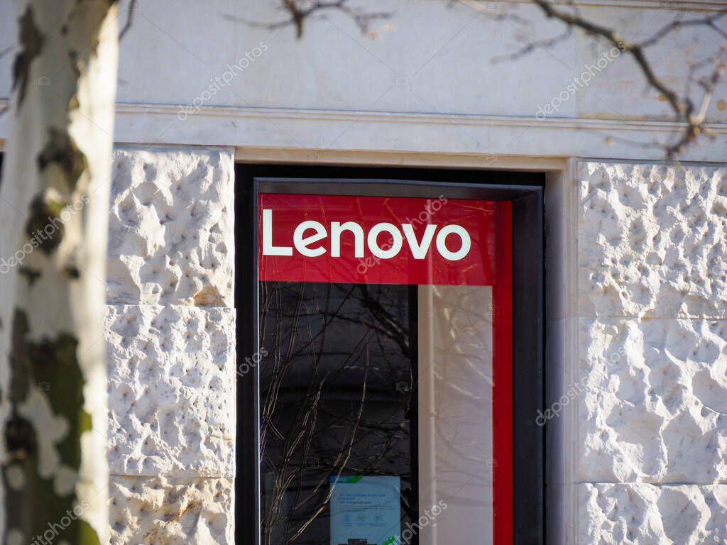 Lenovo Store Front with Red Logo Displayed on White Textured Wall in Urban Setting