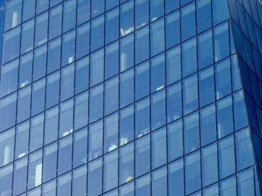 Mavi Cam Gökdelen Cephesi 'nin Geometrik Yansımalarla Soyut Yakın Çekimi Açık Gökyüzü Altında Büyüleyici Örüntü Oluşturur