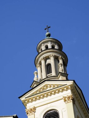 Tarihi Varşova bölgesinde parlak mavi gökyüzüne karşı altın dekoratif unsurlarla donatılmış zarif kilise çan kulesi.