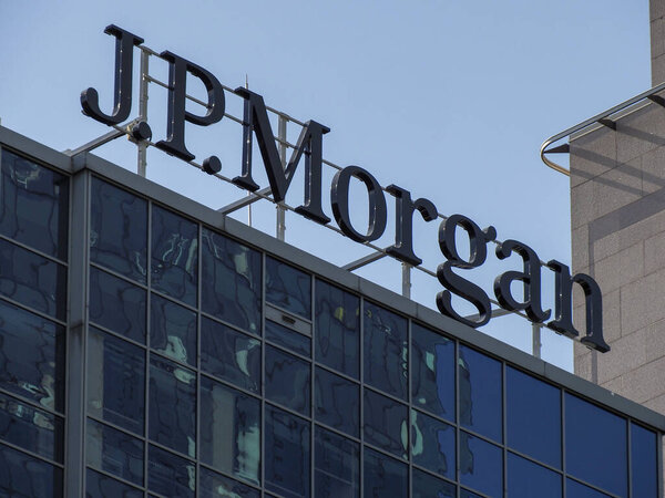 JP Morgan Corporate Headquarters Logo Displayed on Modern Glass Office Building Against Clear Blue Sky