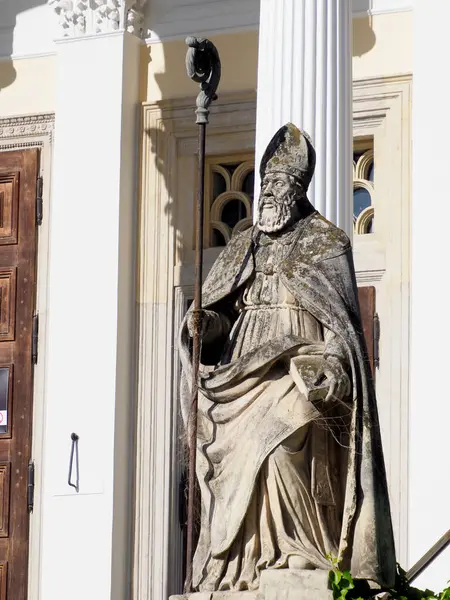 Antik Taş Aziz Heykeli Beyaz Kilise Duvarına Karşı Kutsal Kitap Tutuyor