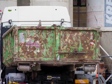 Paslı Yeşil Endüstriyel Konteynır ve Şehir İnşaat Alanındaki Beyaz Araç Yenileme sırasında
