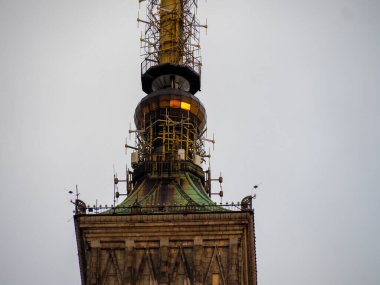 Tarihi Varşova saat kulesi mimari detayı. Karmaşık metal işleri ve antenlerle.