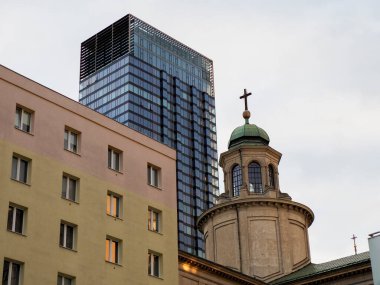 Eski ve yeni mimarinin aksine tarihi kilise kubbesinin üzerinde yükselen modern cam gökdelen kulesi.