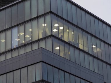 Aydınlatılmış İç Gösterim Gecesi Ortamı ile Modern Cam Ofis Binası Köşesi Görünümü