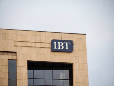 İş Bölgesi 'nde Bulutlu Gökyüzüne Karşı Şirket Logosuyla Modern IBT İnşaat Cephesi