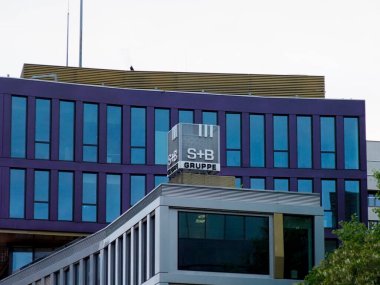 Özgün S + B logosu ve Geometrik Mimarisi olan Modern Mavi Ofis Binası