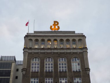 Şehir merkezinde Orange Ampersand Logo ve Polonya Bayrağına Karşı Mavi Gökyüzü Tarihi Bankacılık Binası