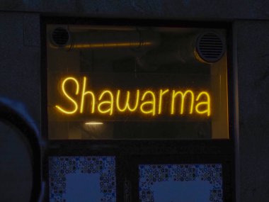 Gece vakti Karanlık Restoran Penceresinde Parlayan Sarı Shawarma Neon Tabelası