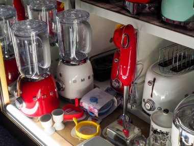 Kırmızı blenderlı şık mutfak tezgahı ve ev yemekleri için çeşitli cam kapların yanına yerleştirilmiş yemek işlemcisi.