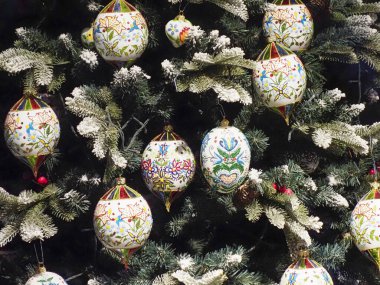 Evergreen Dalları 'nda Karmaşık Halk Sanatları desenleriyle süslenmiş güzel Noel Ağacı Süslemeleri