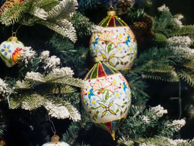 Geleneksel El Boyaması Noel Yumurtası Süslemeleri Çiçek desenleri Karlı Evergreen Dalları Arasında Asılı