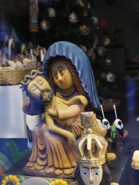 Geleneksel dini figürlerde halk sanatı tarzında canlı renkler ve süslü detaylarla süslenmiş Madonna ve çocuk tasvir ediliyor.